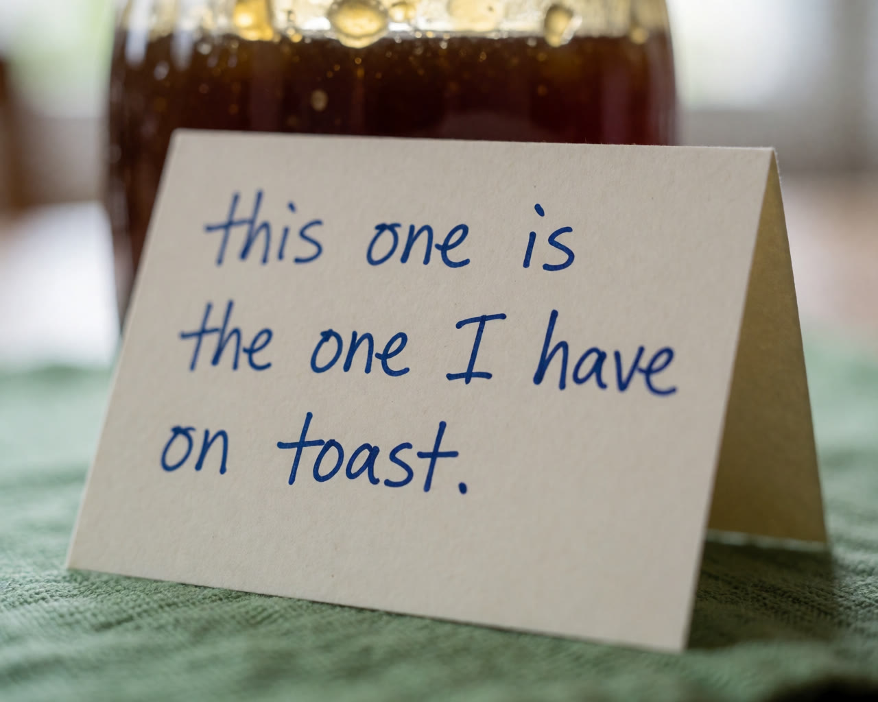 A small handwritten card propped against a jar of honey